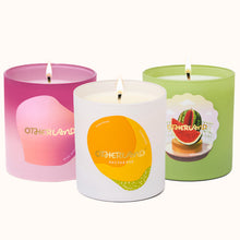 Three scented candles with colorful labels on a white background