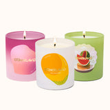 Three candles with colorful labels and 'Otherland' branding on a white background