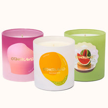 Three scented candles with colorful labels on a white background