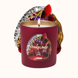 Red candle with decorative label featuring 'Otherland' on a white background