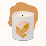 Candle in a white container with a label featuring an illustration of cardamom pods on a white background.