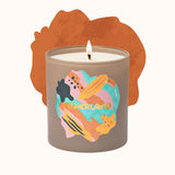 Candle in a decorative container with abstract design on a white background