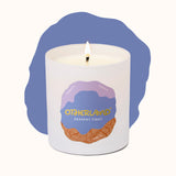 White candle in a container with 'Otherland' branding on a white background