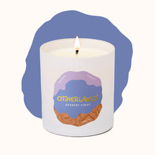 White candle in a container with 'Otherland' branding on a white background
