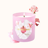 Pink candle with floral design and 'Otherland' branding on a white background