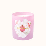 Pink candle with floral design and 'Otherland' branding on a white background