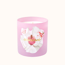 Pink candle with floral design and 'Otherland' branding on a white background