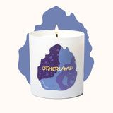 Candle with 'Otherland' branding on a white background