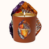 Candle in a decorative container with gemstone design on a white background
