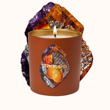 Candle in a decorative container with gemstone design on a white background