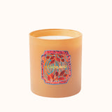 Candle with a colorful label on an orange container against a white background