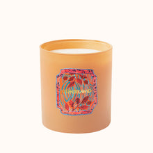 Candle with a colorful label on an orange container against a white background