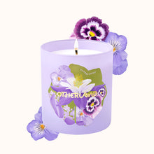 Purple candle with floral design and 'Otherland' branding on a white background