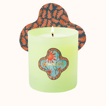 Green candle with a decorative lid featuring abstract designs on a white background