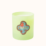 Green candle with a colorful logo on a white background