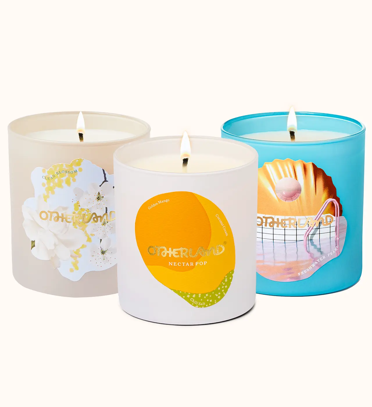 Three candles with different designs on their containers against a white background - View 1