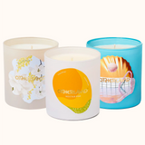 Three candles with different designs on their containers against a white background