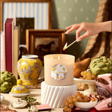 Hand lighting a candle with decorative items around