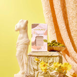 Pura refill product on a decorative stone pedestal with flowers and a statue against a yellow background