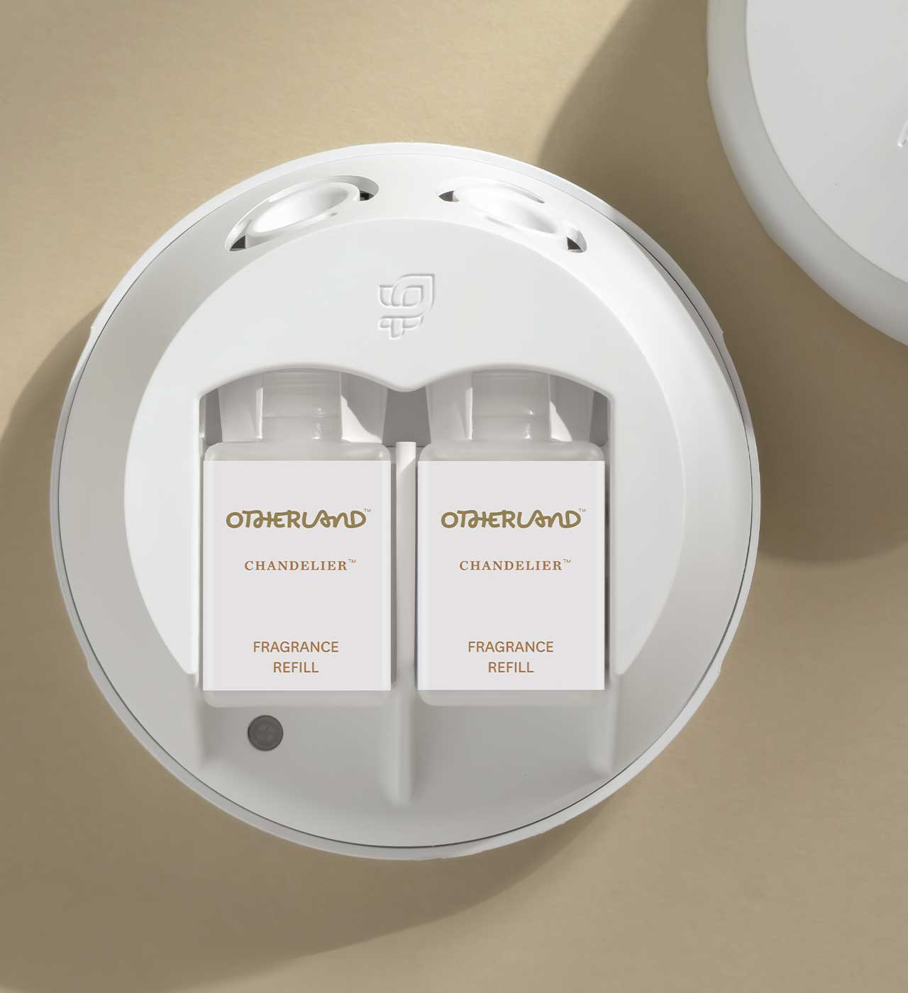 White fragrance refills in a Pura dispenser with 'Otherland' branding on a beige background - View 3