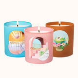 Three candles in colorful tins with artistic designs on a white background