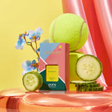 Pura refill product with a tennis ball, cucumber slices, and flowers on a colorful background