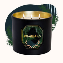 Black candle with gold interior and 'Otherland' logo on a white background